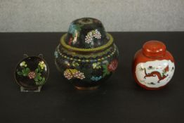 A Japanese Cloisonné enamel floral design lidded urn, black ground with colourful peonies and