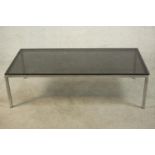 A 1970's coffee table, of rectangular form with a smoked plate glass top on a chromed steel base.