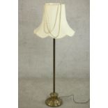 A 20th century standard lamp with a circular brass base and a white shade. H.147 Dia.59cm.