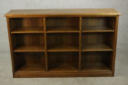 A late 19th century oak open bookcase, the shelves and dividers with chamfered edges, on a plinth