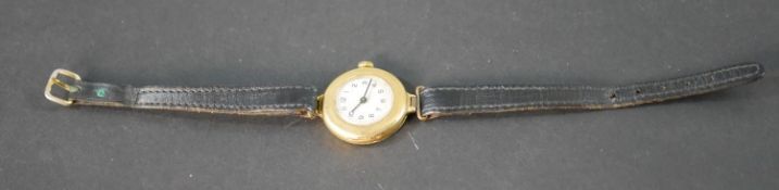 An 18ct carat gold vintage automatic ladies watch with white enamel dial and black leather strap.
