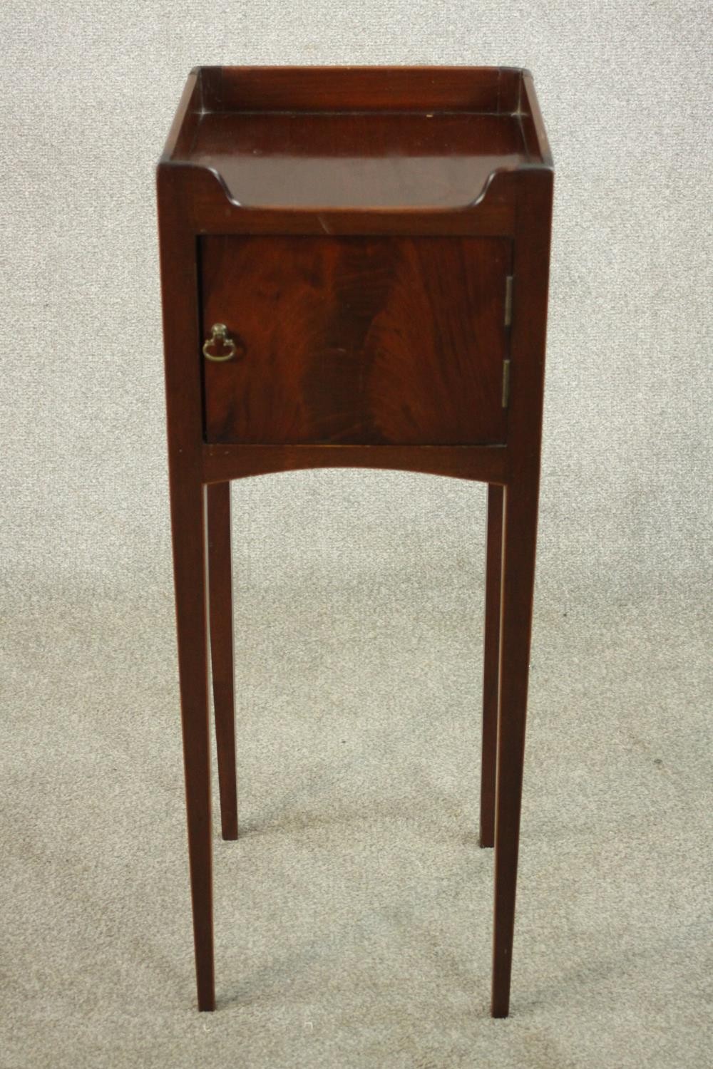 A 19th century mahogany night table, with a gallery top over a cupboard door, on slender tapering