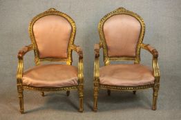 A pair of Louis XVI style giltwood fauteuil armchairs, upholstered in pink fabric to the back,