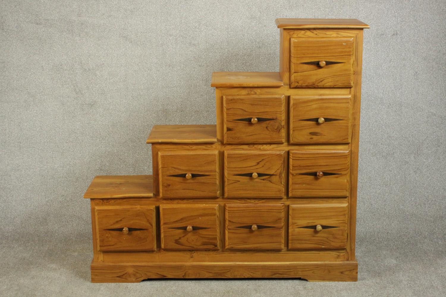 A contemporary pine stepped chest in the style of a Japanese kaidan tansu, with an arrangement of
