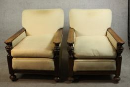 A pair of early 20th century oak armchairs, upholstered in cream fabric, with carved cup and cover