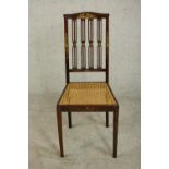 A circa 1900 Sheraton inspired side chair, painted with flowers, with a caned seat, on slender