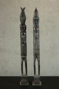 Two carved and painted Ugandan African figures. H.100 W.12 D.12cm.