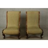 A pair of Victorian walnut slipper chairs, with striped upholstery and on carved scrolling legs.