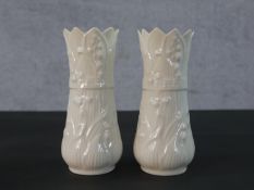 A pair of Belleek vases, with flared rims and moulded decoration along with a Belleek jug, with a