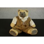 A painted papier mache teddy bear in a hessian suit. H.37 W.28 D.12cm.