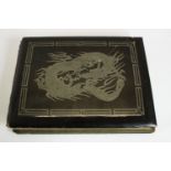 A Japanese black lacquer covered photo album with silver dragon design containing early 20th century