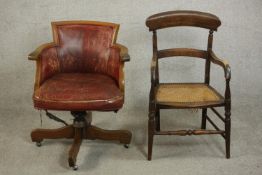 An early 20th century swivel desk chair uoholstered in burgundy leather, on a four point base,