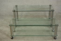Two contemporary home entertainment stands, plate glass with rounded corners on cylindrical metal
