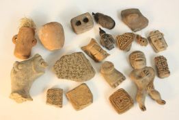 A collection of eighteen antiquities, including clay tile fragments, Mexican clay figures, a bell