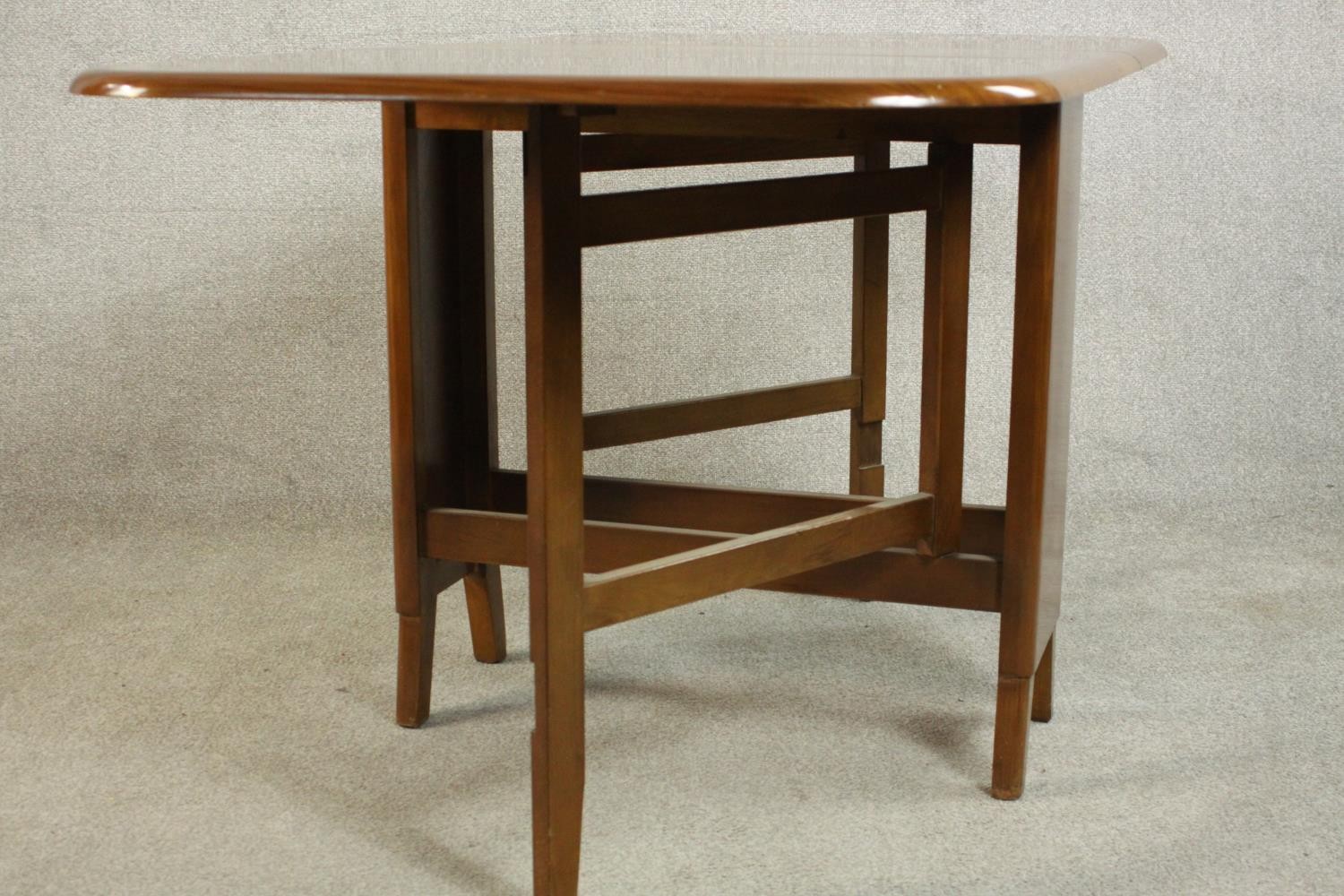 A mid 20th century walnut drop leaf dining table, the two leaves with rounded corners on a base with - Image 5 of 9