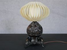 An early 20th century carved coconut design table lamp with silk finned shade on tripod elephant