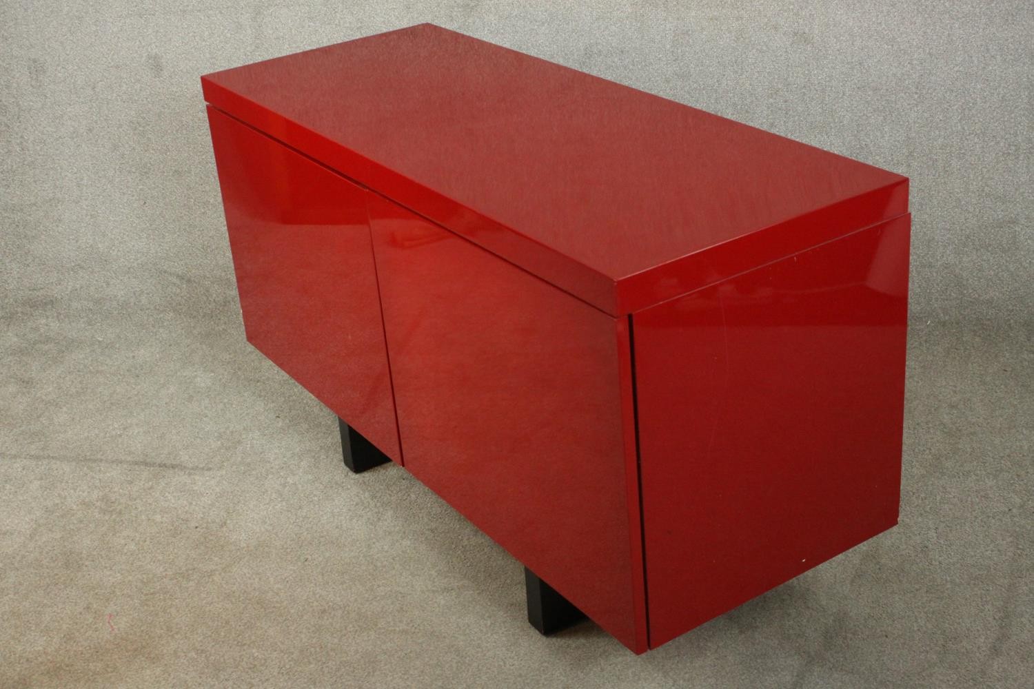 A contemporary red lacquered sideboard with two cupboard doors, on black lacquered supports. H.74 - Image 12 of 14