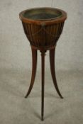 An Edwardian Regency style mahogany planter, with slatted sides and a drop in copper liner, on three