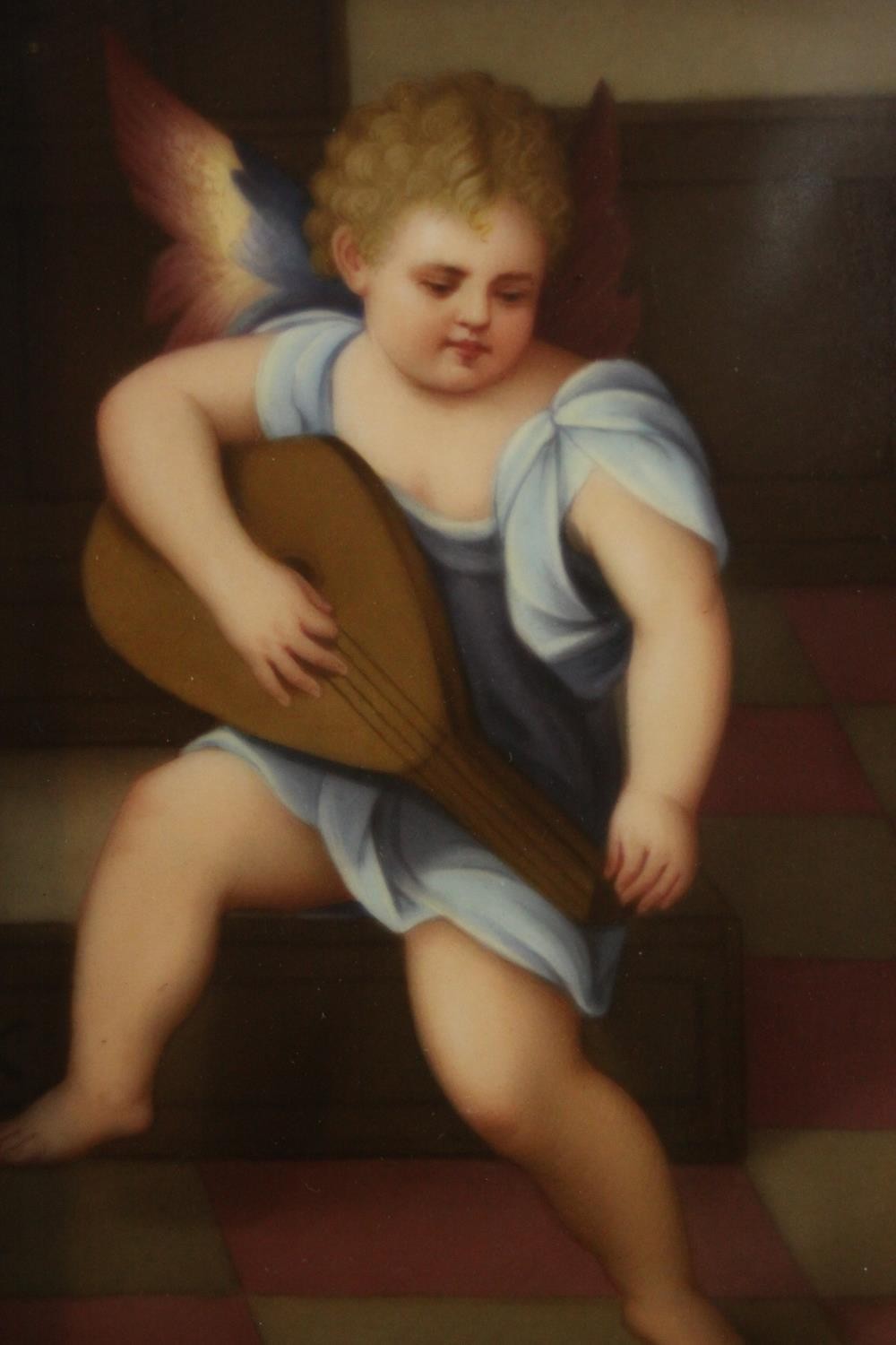 A framed painting on porcelain of an angel playing a lute, inscribed in pencil and stamped