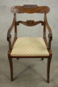 A William IV mahogany open armchair, with a carved bar back over scrolling arms above a drop in