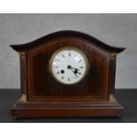 A late 19th/early 20th century mahogany and inlaid mantel clock, with a serpentine top, the