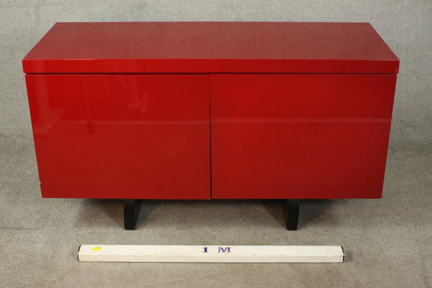 A contemporary red lacquered sideboard with two cupboard doors, on black lacquered supports. H.74 - Image 2 of 14