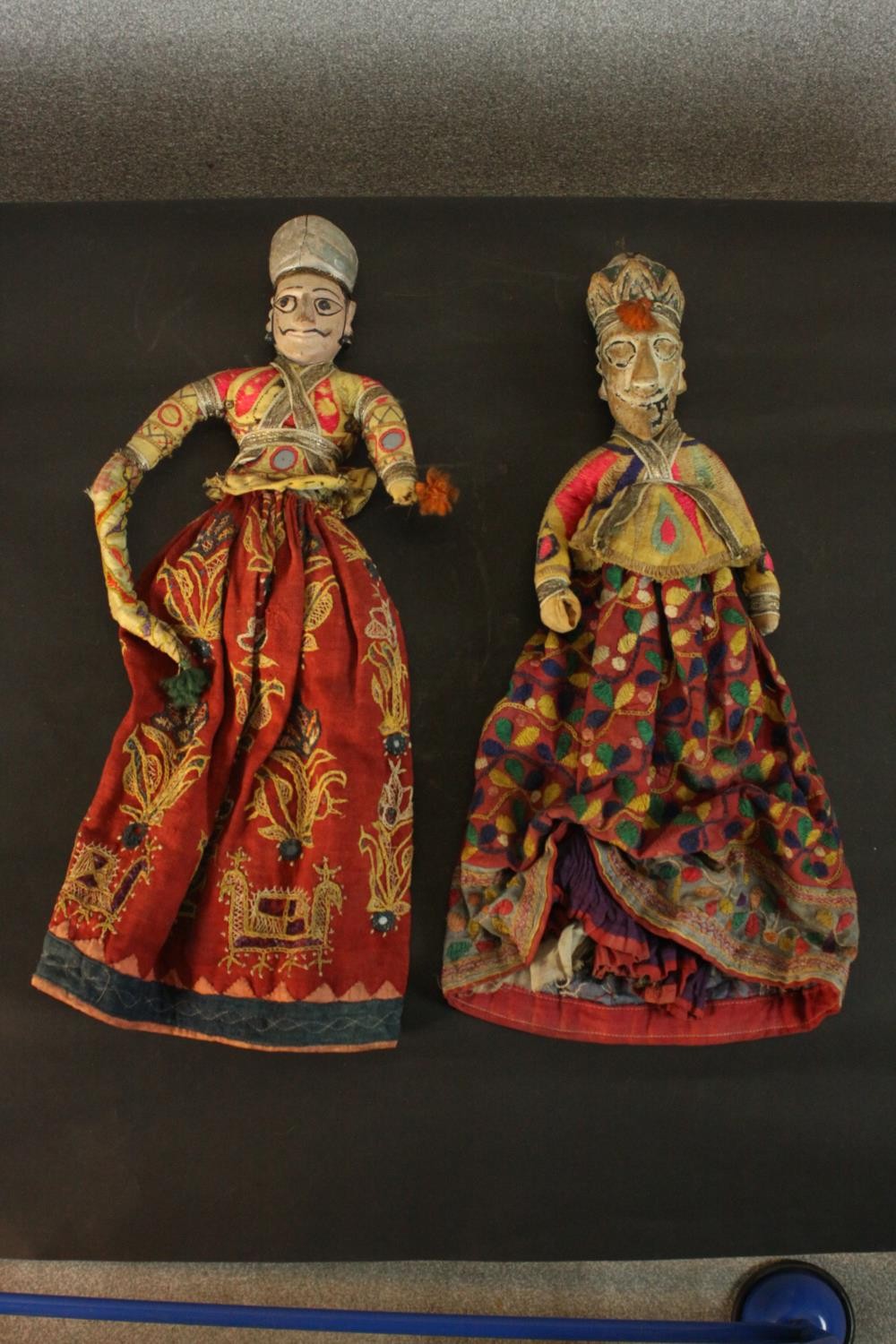 Two 19th century carved and painted Indian dolls in embroidered traditional costumes, the robes with