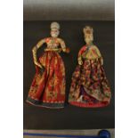 Two 19th century carved and painted Indian dolls in embroidered traditional costumes, the robes with