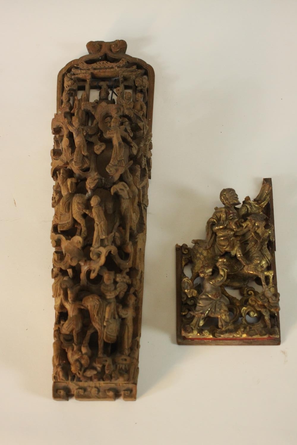Two Chinese carved wood furniture panels, one carved with a procession of figures queueing to meet