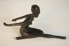 A bronze figure of an African dancer arms behind and one knee bent. H.15 W.25 D.7cm.