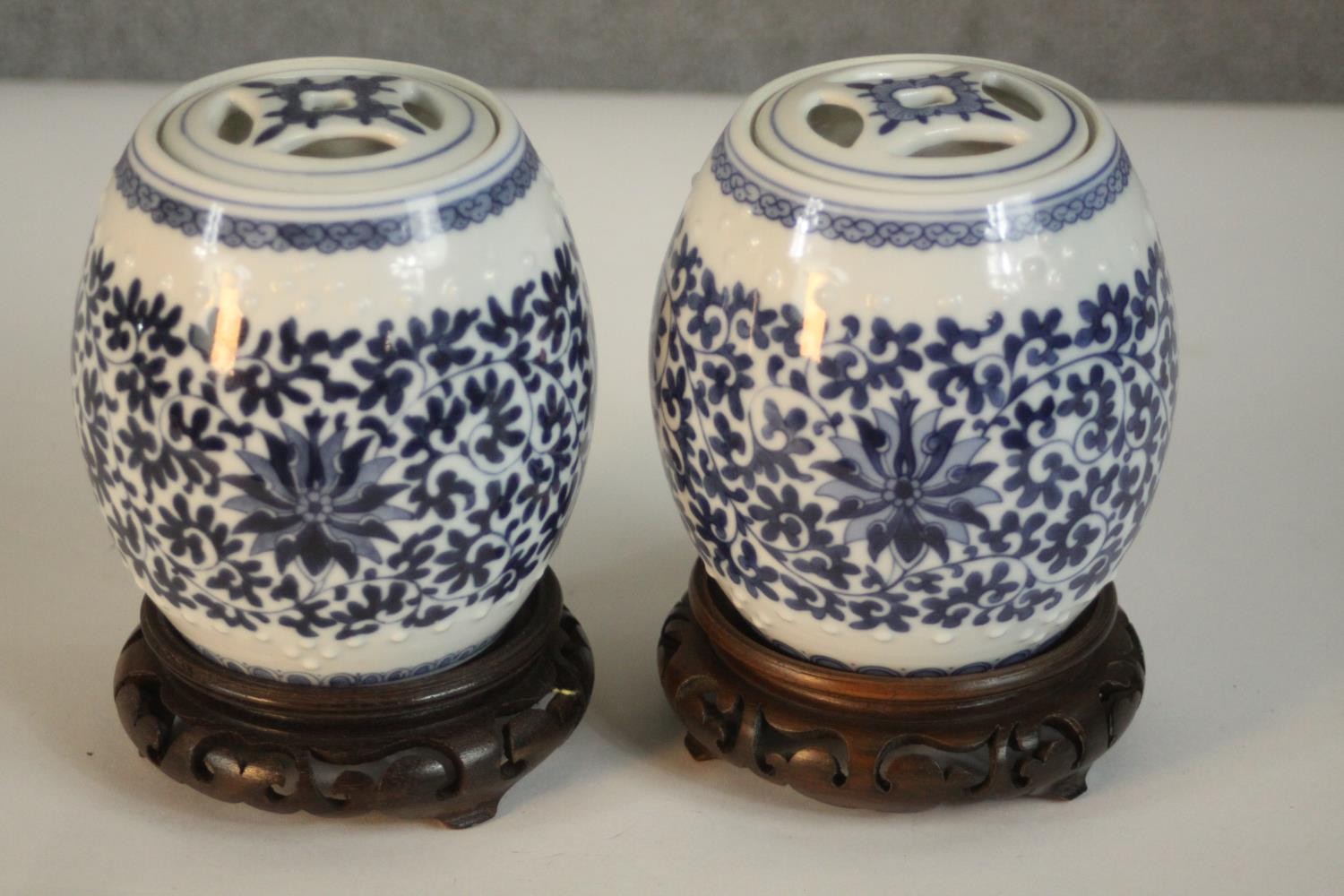 Two blue and white miniature porcelain lidded jars in the form of Chinese stools with stylised