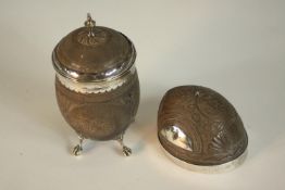 Two Georgian carved coconut vessels, one lidded cup with white metal mounts and on four claw and