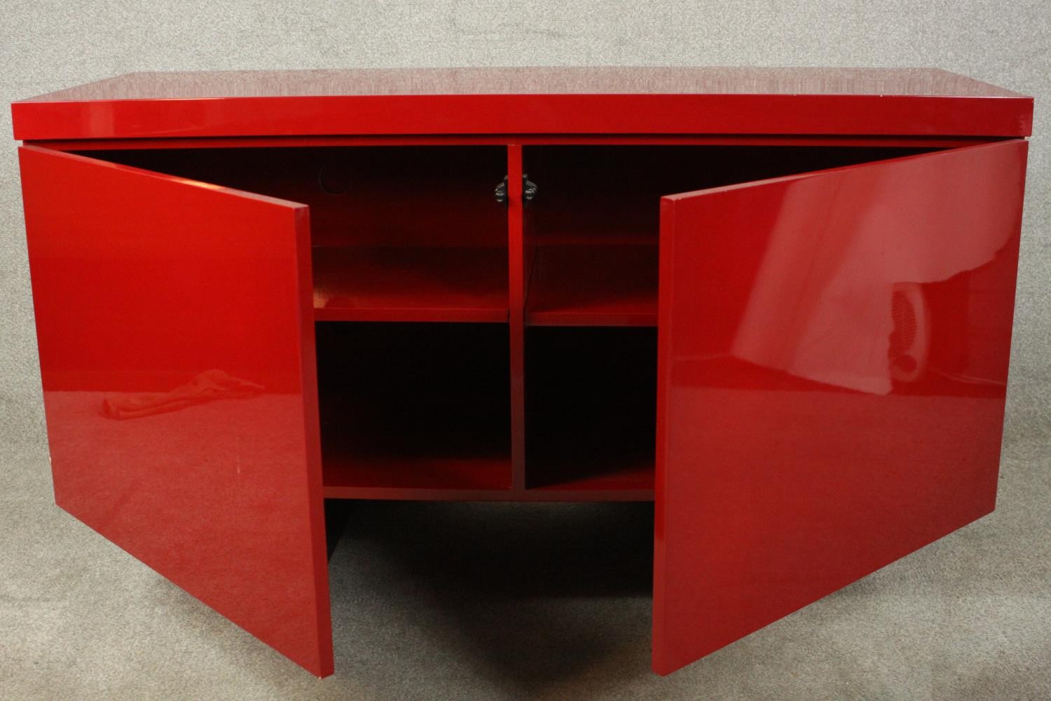 A contemporary red lacquered sideboard with two cupboard doors, on black lacquered supports. H.74 - Image 9 of 14