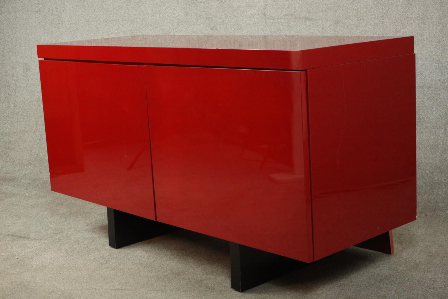 A contemporary red lacquered sideboard with two cupboard doors, on black lacquered supports. H.74 - Image 10 of 14