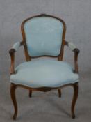 A Louis XV style walnut fauteuil armchair, upholstered in blue fabric to the back, arms and seat, on