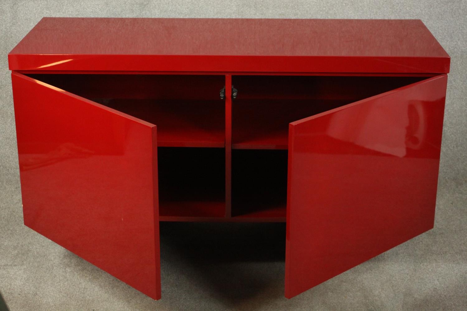 A contemporary red lacquered sideboard with two cupboard doors, on black lacquered supports. H.74 - Image 4 of 14