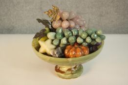 A carved alabaster pedestal fruit bowl filled with various marble and gemstone fruit and vegetables,