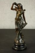 A late 19th/early 20th century painted spelter figure of a lady stroking her hair, on an ebonised