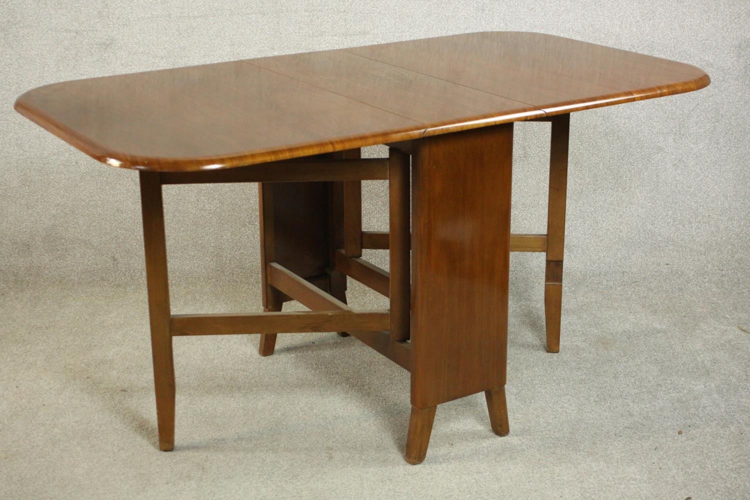 A mid 20th century walnut drop leaf dining table, the two leaves with rounded corners on a base with - Image 3 of 9