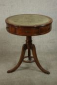 A reproduction George III style mahogany drum table with a tooled green leather insert over