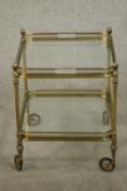 A brass two tier drinks trolley, each plate glass tier with a pierced brass gallery, on brass