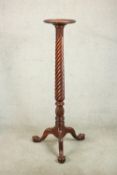 A Victorian style mahogany torchere, with a dished top on a wrythen column on tripod legs