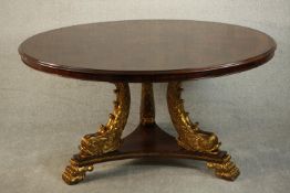 A circular flame mahogany dining table, possibly by Maitland-Smith, centred by a marquetry inlaid