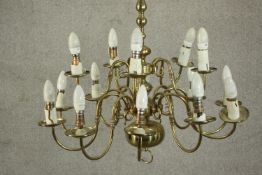 A Dutch style brass chandelier, with fourteen scrolling branches in two tiers. H.70 Dia.75cm.