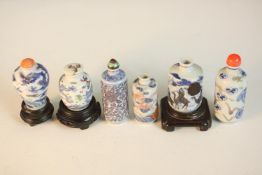 A collection of six Qing dynasty hand painted porcelain snuff bottles, three with stoppers, three