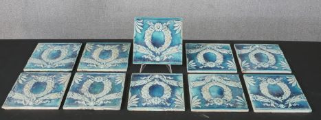 A set of ten Minton, Hollins & Co tiles, decorated with a wreath wrapped in ribbons, glazed in blue.