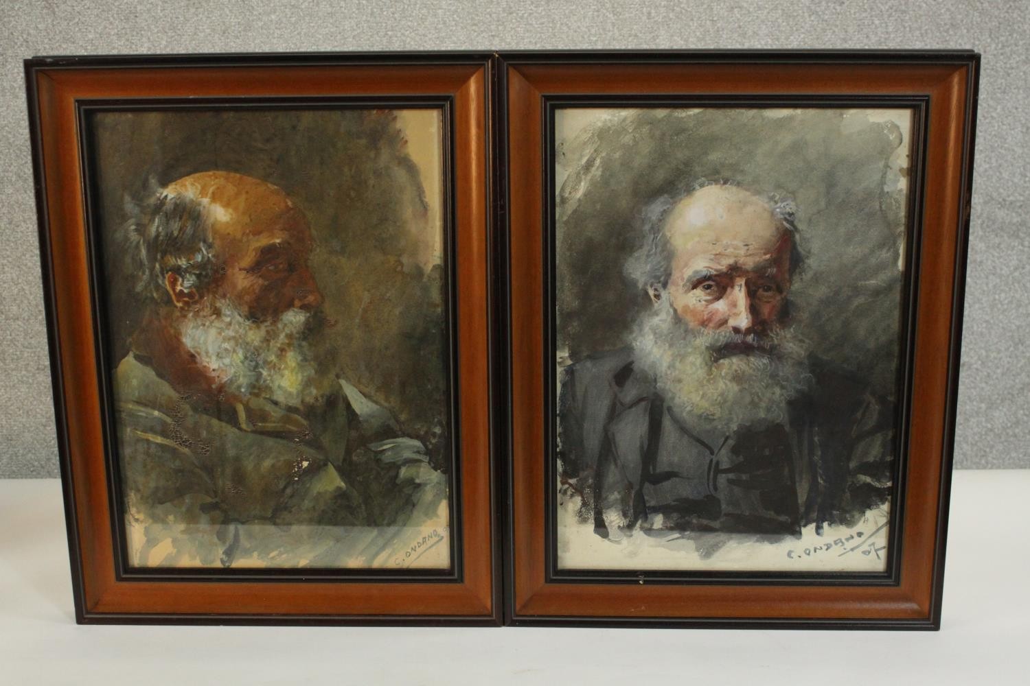 Two framed and glazed watercolour portraits of an old man with a beard, one from the side and one