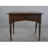 A Victorian carved oak lowboy, the top with a brown leather insert and a carved moulded edge over