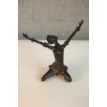 A bronze figure of an African woman with traditional headdress kneeling with arms open. H.26 W.26