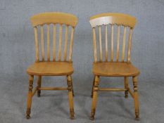 A pair of French beech bar back kitchen chairs with turned legs joined by H stretchers, stamped to